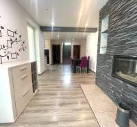 Innenraum eines Einfamilienhauses mit Kamin, Holzboden und Wanddekoration.