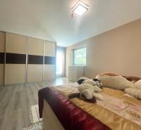 Schlafzimmer in einem Einfamilienhaus mit Holzboden, Einbauschrank und Plüschtieren.