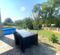 Die Terrasse des Einfamilienhauses in Melčice-Lieskové mit Blick auf den Garten und den aufblasbaren Pool.
