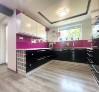 Küche mit weinroten Elementen und Holzboden in einem Einfamilienhaus.