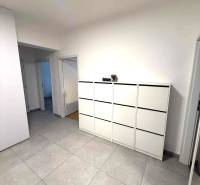 Ein geräumiger Flur mit hellen Fliesen und einer weißen Kommode in einer 4-Zimmer-Wohnung.