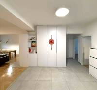 Flur in einer 4-Zimmer-Wohnung mit weißen Einbauschränken und Keramikfliesen.