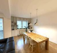 Esstisch in einer 4-Zimmer-Wohnung mit Holzboden und weißen Stühlen.