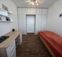 Innenraum einer 3-Zimmer-Wohnung mit Bett, Schreibtisch und Einbauschrank.