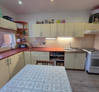 Küche in einer 3-Zimmer-Wohnung mit einer Küchenzeile in Cremefarbe und einem Boden in Holzoptik.