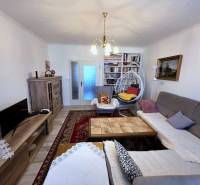 Wohnzimmer in einer 3-Zimmer-Wohnung mit Holzboden und Bücherregalen.