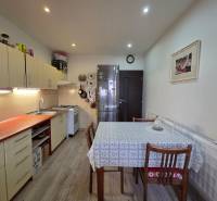 Küche in einer 3-Zimmer-Wohnung mit Holzboden und Esstisch.