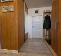 Flur in einer 3-Zimmer-Wohnung mit Holzdekor und Garderobenwand.