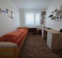 Einfach eingerichtetes Schlafzimmer oder Arbeitszimmer in einer 3-Zimmer-Wohnung mit Bett und Schreibtisch.