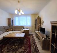 Wohnzimmer in einer 3-Zimmer-Wohnung mit Ecksofa und Holzboden.