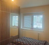 Schlafzimmer im Einfamilienhaus mit großem Schrank und Bett mit sternförmiger Bettwäsche.