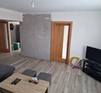 Wohnzimmer mit Holzboden, Sitzgarnitur und Fernseher in einem Einfamilienhaus.