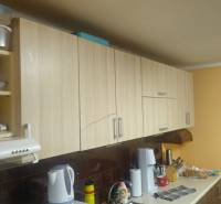 Küche in einem Einfamilienhaus mit Holzschränken und Zubehör auf der Küchenarbeitsplatte.