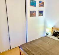 Schlafzimmer in einer 2-Zimmer-Wohnung mit Bett, Einbauschrank und Wanddekorationen.