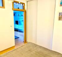 Innenraum einer 2-Zimmer-Wohnung mit Schiebetüren und Boden in Holzoptik.