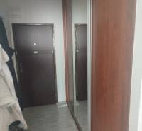 Flur mit Fliesen und einem großen Spiegel in einem Studio.