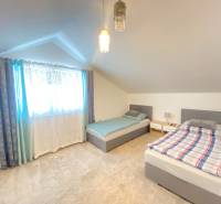 Ein Dachzimmer mit zwei Betten und einem weichen Teppich in einem Einfamilienhaus.