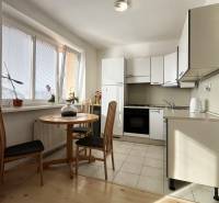 Küche in einer Einzimmerwohnung mit rundem Tisch und Holzboden.