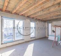 Ein Gebäude in Veľké Leváre mit großen Fenstern und einer Holzdecke, Vorbereitung für das Interieur.