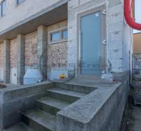 Ein Gebäude in Veľké Leváre mit unvollendeter Fassade und Treppen auf einem Betonfundament.