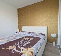 Schlafzimmer mit Weihnachtsbettwäsche, Tapete und Blumen in einer 3-Zimmer-Wohnung.