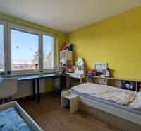 Kinderzimmer in einer 3-Zimmer-Wohnung mit Bett, Schreibtisch und Boden mit Holzdekor.