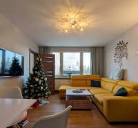 Wohnzimmer in einer 3-Zimmer-Wohnung mit gelbem Sofa und Holzboden.