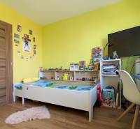 Kinderzimmer mit Möbeln und Dekorationen, Boden mit Holzdekor, angenehmer Raum in einer 3-Zimmer-Wohnung.