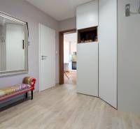 Eingangsbereich einer 3-Zimmer-Wohnung mit großem Spiegel, Bank und Boden in Holzoptik.