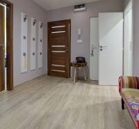 Diele in einer 3-Zimmer-Wohnung mit einem Boden in Holzoptik und einer bunten Bank.