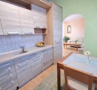 Küchenzeile mit Holzboden und Esstisch in einer 2-Zimmer-Wohnung.