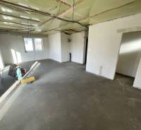 Innenraum eines Einfamilienhauses mit unfertigem Boden und unvollendeter Decke.