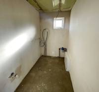 Ein leerer Raum mit einem Fenster in einem Einfamilienhaus, sichtbare Installationen und Vorbereitung für die Einrichtung.