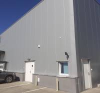 Lagerhäuser und Hallen in der Technická-Straße in Bratislava-Ružinov, mit geparkten Autos vor dem Eingang.