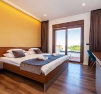 Elegantes Schlafzimmer in einer Villa mit Bett und Boden in Holzoptik.