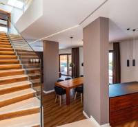 Innenraum der Villa mit Holzboden, Treppe und Esstisch.