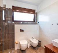 Modernes Badezimmer mit großem Fenster in der Villa, hat eine Dusche und WC.