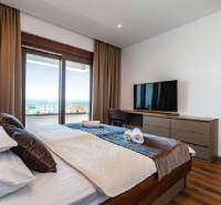 Innenraum der Villa mit Bett, Fernseher und Meerblick.