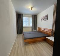 Schlafzimmer mit hellen Wänden, Doppelbett und Boden in Holzoptik in einer 3-Zimmer-Wohnung.