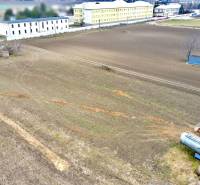 Grundstücke - Wohnen in der Kasárenská-Straße in Sereď mit weitläufigen Feldern und Lagern.