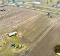 Blick auf Ackerland mit landwirtschaftlichen Maschinen in der Kasárenská-Straße in Sereď, Grundstücke - Wohnen.