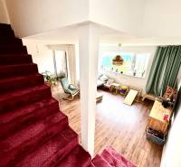 Innenraum eines Einfamilienhauses mit Treppe und Wohnzimmer mit Holzboden.