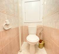 Badezimmer in einer 2-Zimmer-Wohnung mit hellen Fliesen und Toilette.