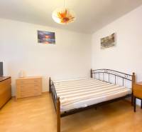 Schlafzimmer in einer 2-Zimmer-Wohnung mit Möbeln und Boden in Holzoptik.