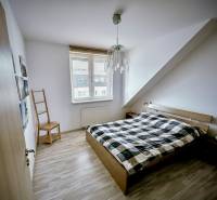 Schlafzimmer in einer 3-Zimmer-Wohnung mit Bett und Holzboden.