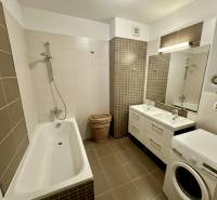 Badezimmer mit Badewanne, Doppelwaschbecken und Waschmaschine in einer 3-Zimmer-Wohnung.