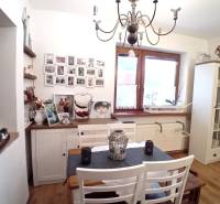 Esszimmer in einem Einfamilienhaus mit weißen Möbeln, Bildern an der Wand und einem dekorativen Kronleuchter.