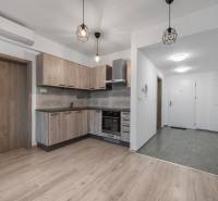 Küche einer 2-Zimmer-Wohnung mit Holzboden und eingebauten Leuchten.