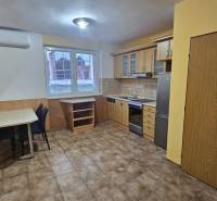 Küche in einer 3-Zimmer-Wohnung mit Küchenzeile, Esstisch und Fliesenboden.