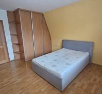 Schlafzimmer mit Holzdekorboden in einer 3-Zimmer-Wohnung, ausgestattet mit einem Bett und einem Einbauschrank.